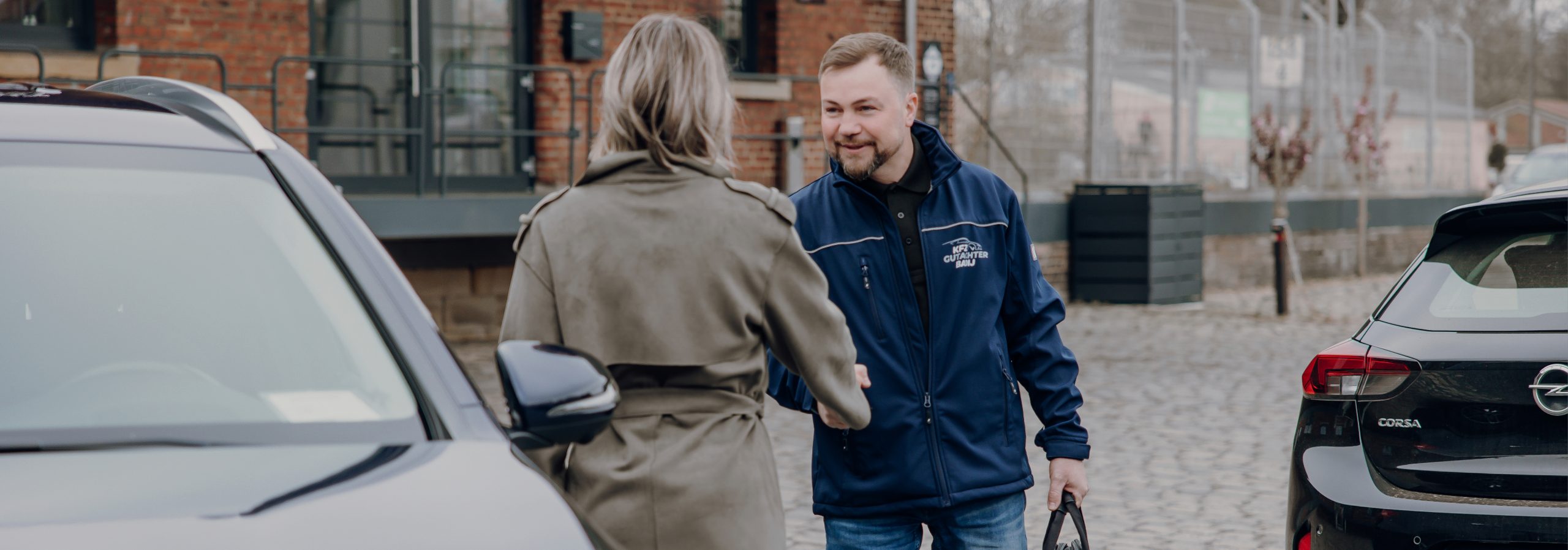 Foto von Viktor Badij mit einer Kundin vor einem Auto. Sie begrüßen sich.