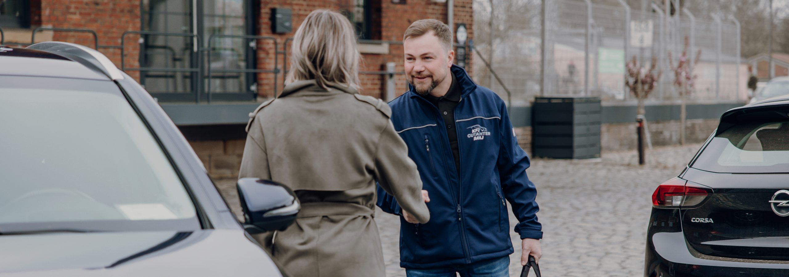 Foto von Viktor Badij mit einer Kundin vor einem Auto. Sie begrüßen sich.